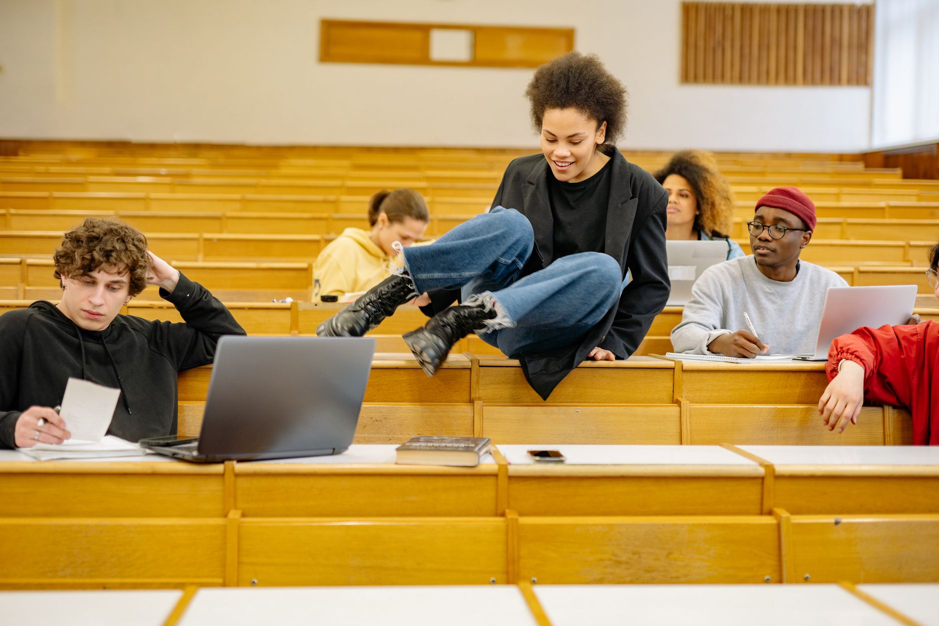 Diverse students interact and study in a university lecture hall.